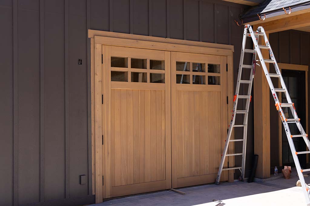 Freshly Painted Wooden double doors set with a ladder leaning against the wall.